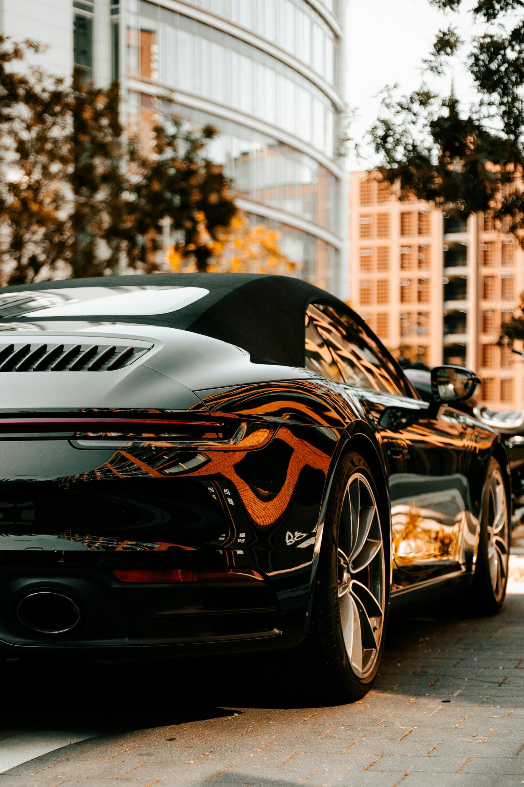 A luxury black sports car parked outdoors in a modern urban environment. Stylish and sleek.